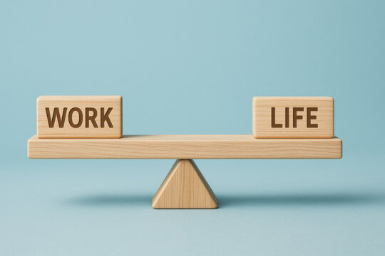 Wooden blocks with the words WORK and LIFE balanced on a seesaw with a triangular support against a light blue background