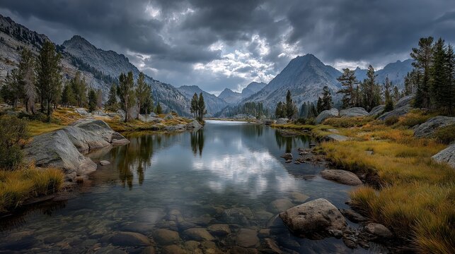 Wide-angle landscape photo of a clear alpine lake surrounded by rocky mountains, perfectly reflecting dark, dramatic storm clouds in the clear water.