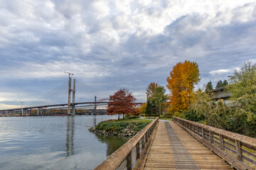 Fototapeta premium Autumn Waterfront Walkway With Bridge Under Construction In New Westminster, Greater Vancouver, BC Canada