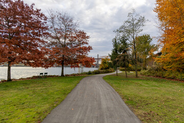Autumn Riverside Path in New Westminster Park With Colorful Trees and Calm Water View