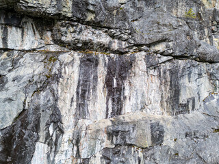 Rugged Gray Rock Face With Vertical Cracks and Moss in a Mountain Cliff, Canada