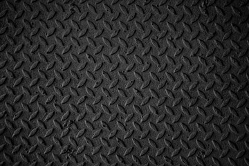 A black and white photo of a metal surface with a pattern of squares