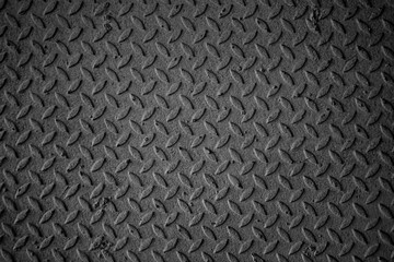A black and white photo of a metal surface with a pattern of squares