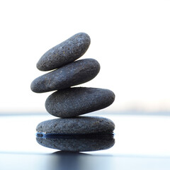 Zen Stone Stack on Reflective Surface Promoting Balance and Tranquility for Spa and Wellness Imagery Four Stones