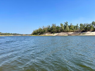 An amazing background of the blue surface of the Dnieper River, barely disturbed by a small ripple surrounding Bayda Island.