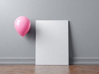 Pink balloon floats beside blank white poster in a grey room