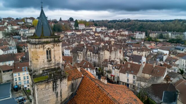 Aerial view captures historic charm of old town Dole in France surrounded by lush green hills, Aerial view of the old town of the city Dole in France on a cloudy afternoon in early spring