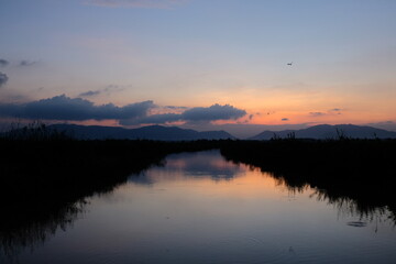 Obraz premium River at Dawn with Mountain Silhouette