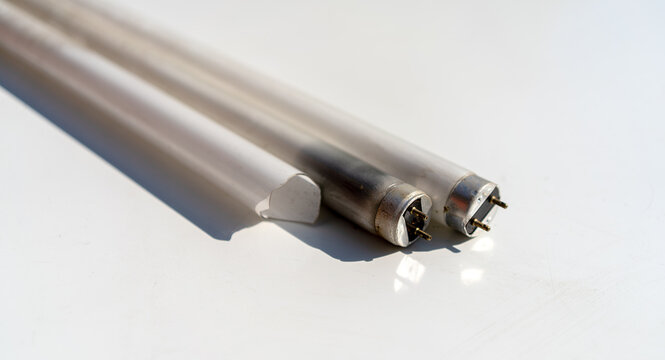 Broken mercury-containing fluorescent lamps on a white background.Hazardous waste.