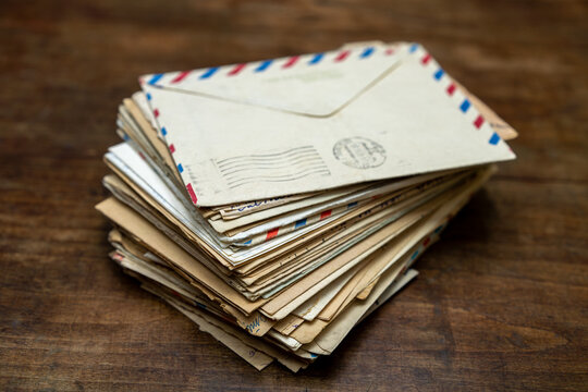 Old letters in envelopes on a wooden table.Memories on paper.A stack of postal envelopes.