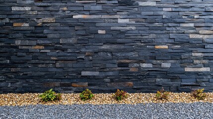 Obraz premium A modern exterior wall texture combining black slate tiles, gravel, and green plants. Perfect for landscaping, garden design, and architectural backgrounds.