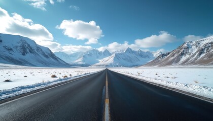 An empty road leads toward snow-covered mountains under a bright blue sky. Winter landscape view road trip concept. Asphalt path surrounded by snowy fields. Scenic background.