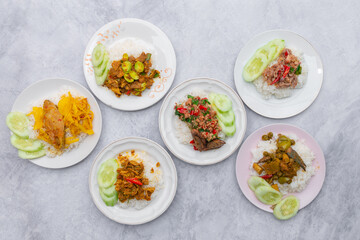 Thai food stir fried with spicy curry paste With different kinds of meat topped on cooked rice