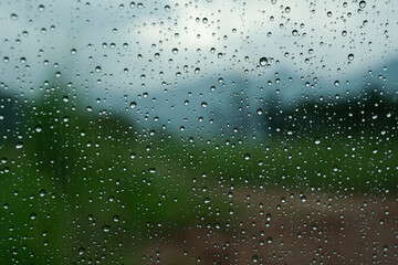 A closeup shot of the glass of a window covered by rain droplets for backgrounds and textures.