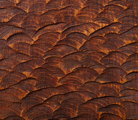 Exquisite reptilian scale texture in warm amber tones, perfect for design projects. Wooden background. Copy space. Top view.