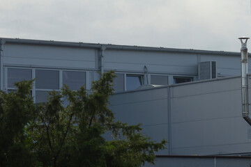 Contemporary cityscape design, Sleek urban office architecture, Stylish building featuring reflective walls and patterns, Minimalist modern workplace with natural and geometric elements integrated