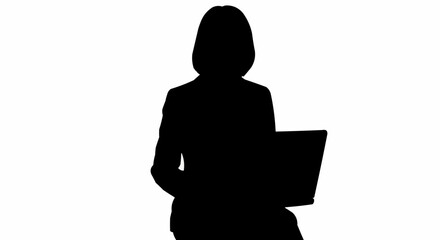 Silhouette of a businesswoman sitting and working on a laptop computer.