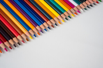 Vibrant colored pencils forming a rainbow gradient on a white background, symbol of creativity, learning, and design inspiration, minimal art style. 