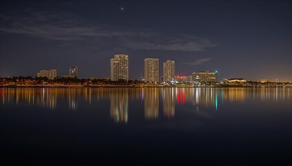 Sarasota Bayfront illuminated at night, reflecting water and urban structures, tourism experience