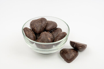 Chocolate-covered gingerbread pieces arranged in a glass bowl on a white background for product photography purposes