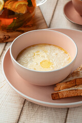 Warm creamy rice porridge with melted butter served with toasted bread on a pink plate