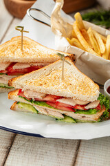 Classic club sandwich with chicken, vegetables and toasted bread served on a plate