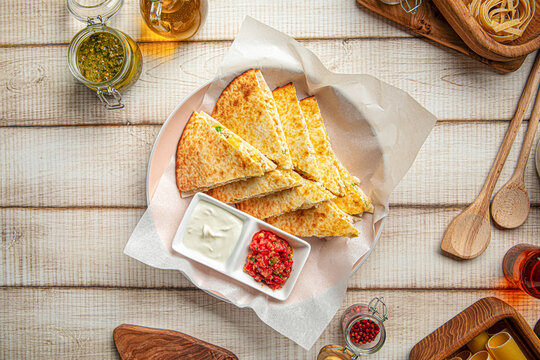 Mexican quesadilla with chicken, cheese, and vegetables served with salsa and sour cream
