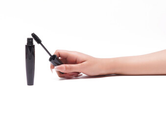 Female hand holding mascara wand with tube on white background, beauty product.