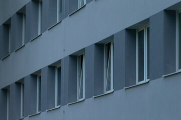 long row of windows on grey facade creating rhythmic repetition and linear composition, broad facade view emphasizing modules and consistent spacing for editorial architecture or pattern orientated