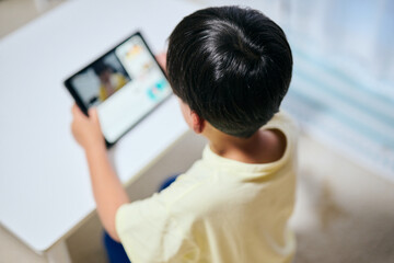 タブレットで動画を視聴する小学生の男の子