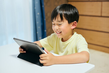 タブレットで動画を視聴する小学生の男の子