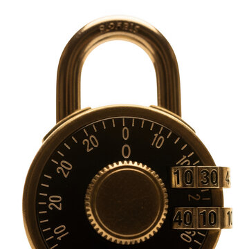 Closeup of a vintage brass combination padlock with a black face and rotating dials, isolated on transparent background