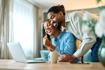 Portrait of a young black man and woman, a young couple, or businessman and businesswoman, using laptop in home office, business and teamwork, cooperation and brainstorming concept