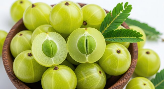 Bowl of fresh green Indian gooseberries with leaves