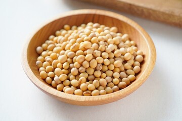 Dried soybeans fill a light wooden bowl soy beans legumes