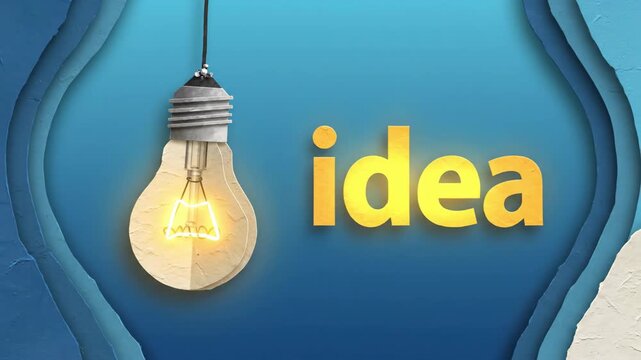 Hanging papercraft lightbulb flickers on, its filament glowing warmly. Yellow word 'idea' materializes next to it against layered blue paper background, representing the emergence of a new concept.