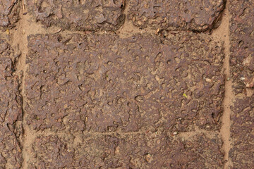 A textured background of real laterite stone, showcasing its unique porous surface and rich reddish-brown color. for rustic rock, natural design themes, construction concepts, and earthy backgrounds