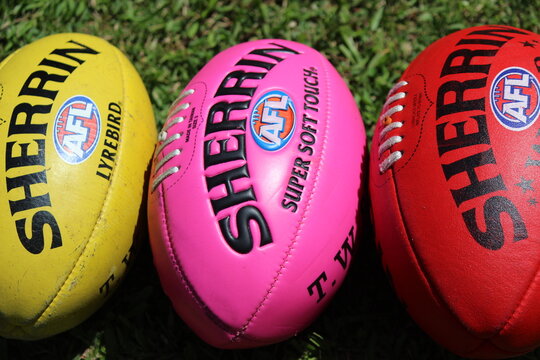 A yellow, pink and red Sherrin Australian rules football