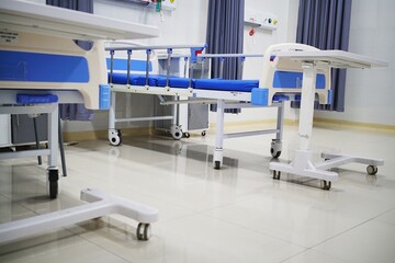 Clean and empty hospital ward with modern medical beds and equipment, ready for patient care.