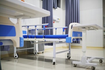 Clean and empty hospital ward with modern medical beds and equipment, ready for patient care.