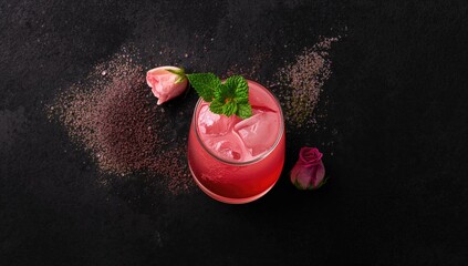 Pink cocktail garnished with roses and mint, suitable for bar menu, seasonal refreshment