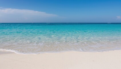 Fototapeta premium White sandy beach meeting a blue ocean that merges with the sky, tranquil coastal scene