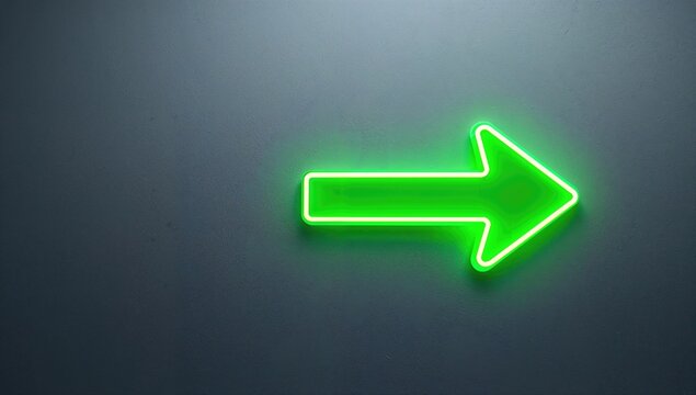 Green neon arrow-shaped pointer on wall, directional guidance in urban settings