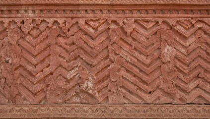 Chevron pattern etched in red sandstone, showcasing intricate Mughal architecture details, preservation