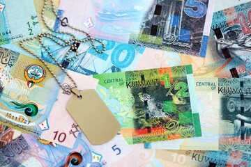 Kuwaiti dinar currency money bills and military token close up. The concept of army service