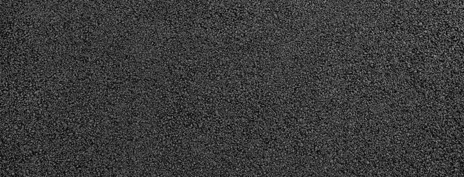 close-up texture of smooth, freshly laid asphalt surface with fine granules and a uniform appearance, neutral background, clear negative space, clean composition, balanced framing, minimalist layout