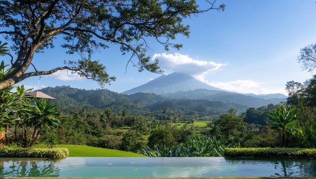 Mount Raung seen from Licin Village, framed by a tree, with a pool in the foreground, seasonal change
