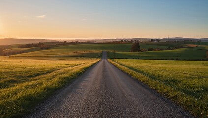 A winding rural path traverses the hills during sunset, highlighting seasonal change