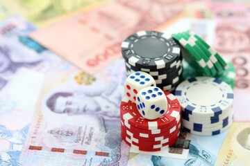 Thai baht currency money bills and casino chips with dices. The concept of gambling and poker casino games