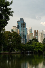 Fototapeta premium Bangkok Skyline by Lumpini Park – Urban Serenity along Rama IV Road, Thailand, Southeast Asia Travel Photography